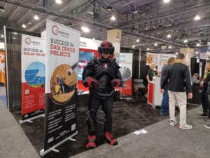 Black armored robot mascot standing at industry trade